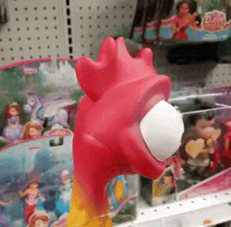 a pink toy with a white egg in its mouth