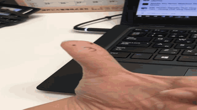 a person 's thumb has the letter c drawn on it