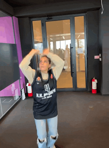 a woman wearing a basketball jersey that says n.i.i. basketball on it