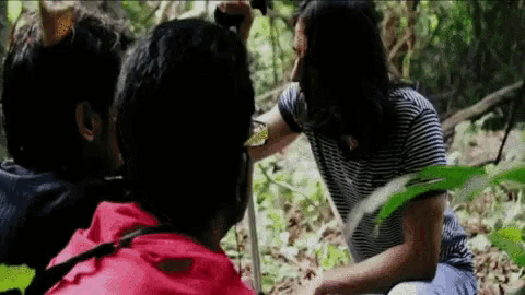 a woman in a striped shirt is talking to a man in a red jacket