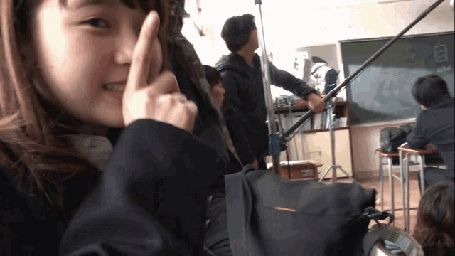 a girl making a peace sign with her fingers