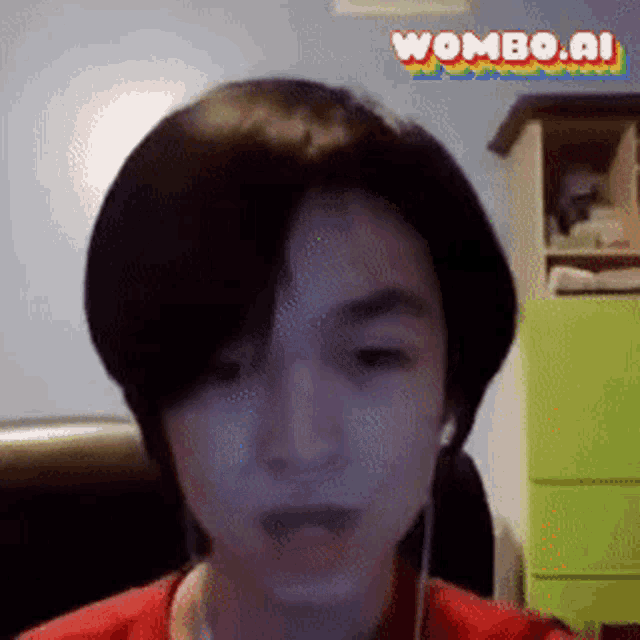 a young man wearing headphones and a red shirt is looking at the camera with the words wombo.ai in the corner .
