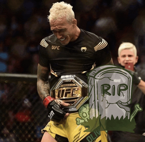 a man wearing a ufc belt stands next to a gravestone