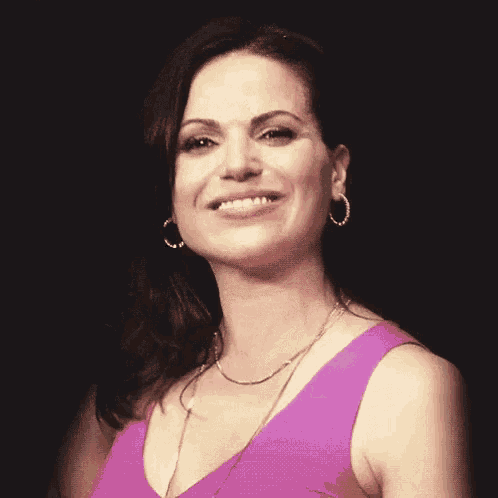 a woman in a purple dress is blowing a kiss with her hand