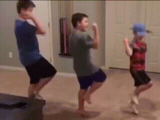 a group of young boys are dancing in a living room .