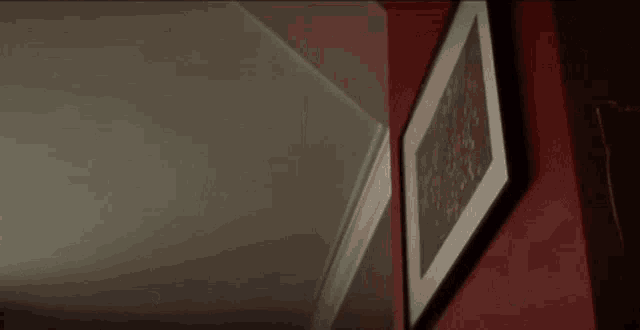 a blurred image of a person hanging a picture on a wall