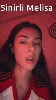 a woman is wearing a red and white shirt with the words sinirli melisa written above her