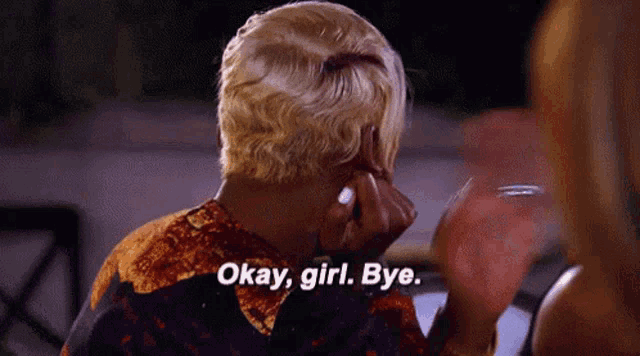 a woman is saying okay girl bye while holding her hand to her face .