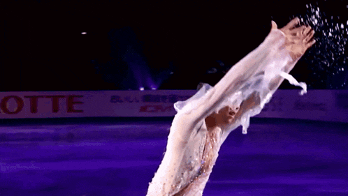 a ice skater performs in front of a lotte sign