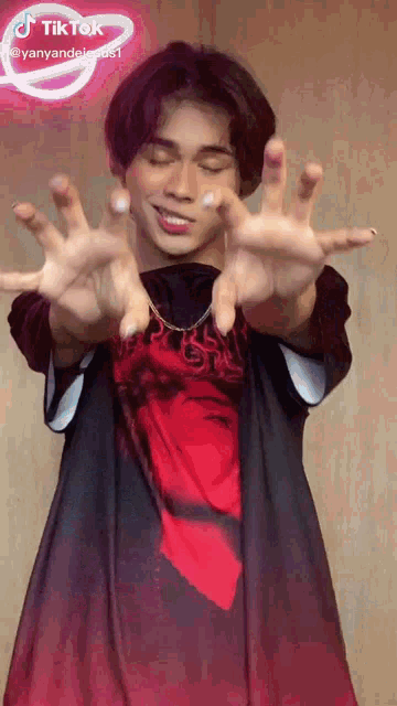 a man in a red shirt has his hands out in front of a tiktok sign