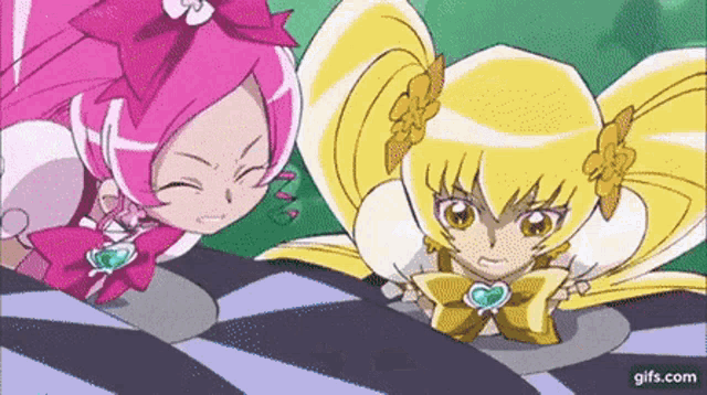 two anime girls are standing next to each other in a cartoon .