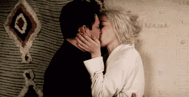 a man and a woman kissing in front of a rug that says boutique