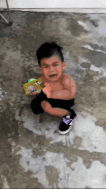 a little boy is crying while holding a book that has a picture of a dog on it