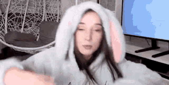 a woman in a bunny costume is sitting in front of a computer screen .