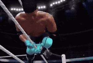 a man in a wrestling ring is wearing a pair of blue gloves .