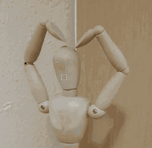 a wooden mannequin with a square on its face