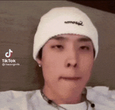 a man wearing a white hat and a white shirt is making a funny face .