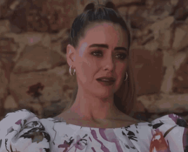 a woman in a floral top is crying