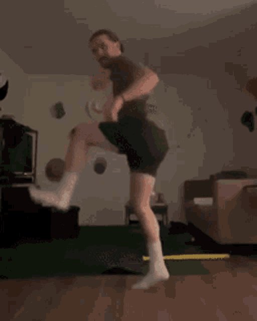 a man is jumping in the air in a living room