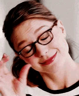 a close up of a woman wearing glasses and making a face .