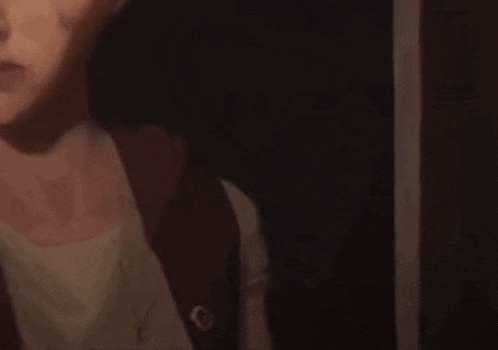 a close up of a woman 's face in a dark room with a blurred background .