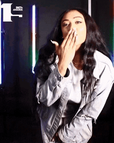 a woman blows a kiss in front of a bet awards logo