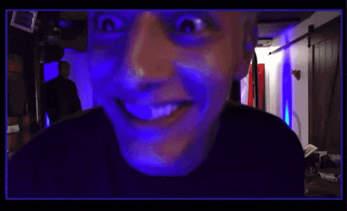 a man is laughing with his mouth open in a dark room .