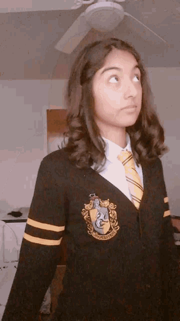 a girl in a harry potter costume is wearing a sweater and tie