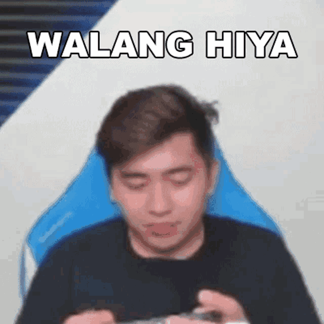 a man is sitting in a chair with his eyes closed while playing a video game on his phone .