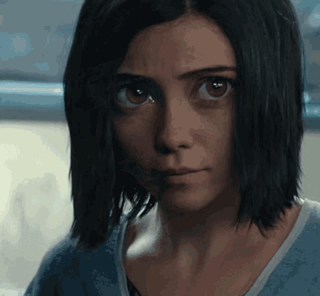a close up of a woman 's face with dark hair and brown eyes