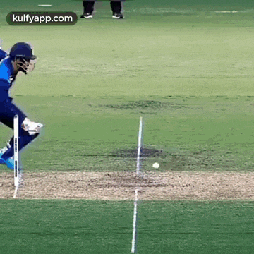 a cricket player is playing a game of cricket and hitting a ball .