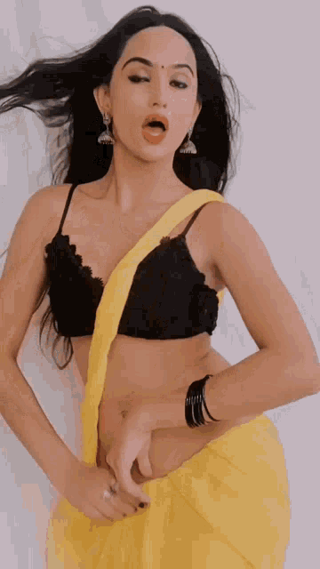 a woman in a yellow saree and black bra