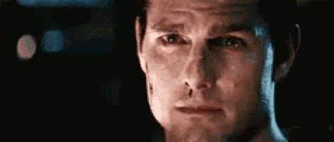 a close up of a man 's face in a dark room with a blurred background .