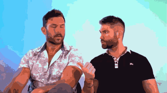 two men are sitting next to each other and one has a tattoo on his arm that says i love you