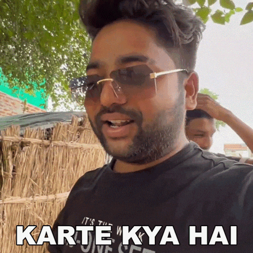 a man wearing sunglasses and a t-shirt that says karte kya hai