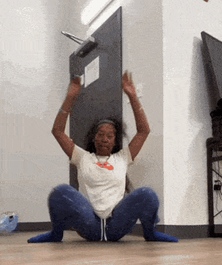 a woman is squatting on the floor in front of a door