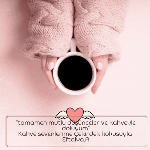 a woman is holding a cup of coffee with a heart and wings on it