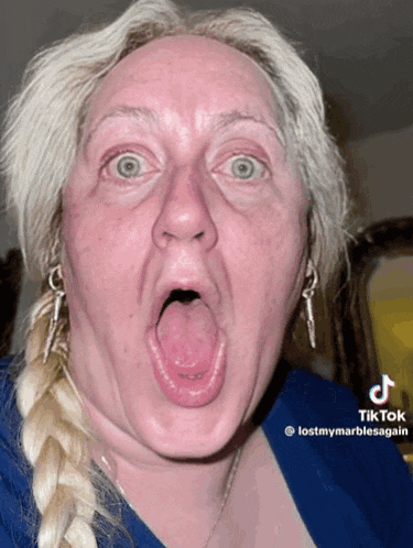 a woman making a funny face with her tongue out and a tiktok watermark
