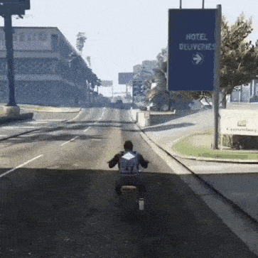 a man is riding a motorcycle down a road in front of a hotel sign