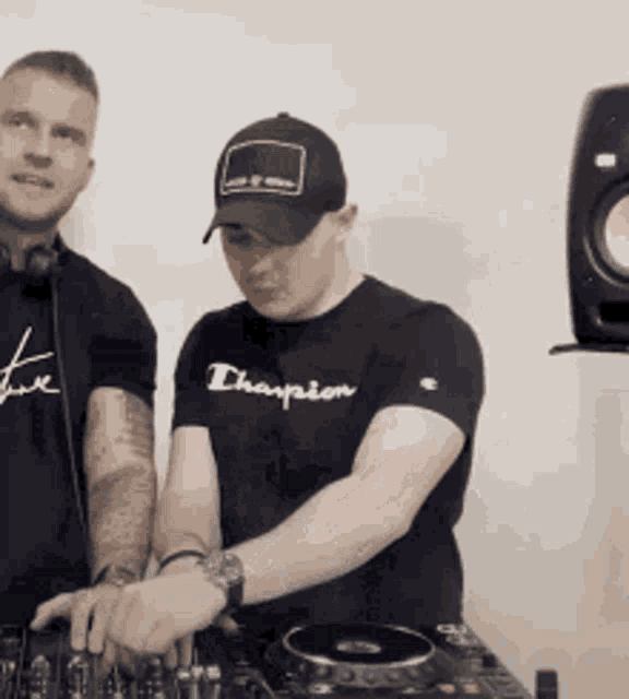 a man wearing a black champion shirt is playing music
