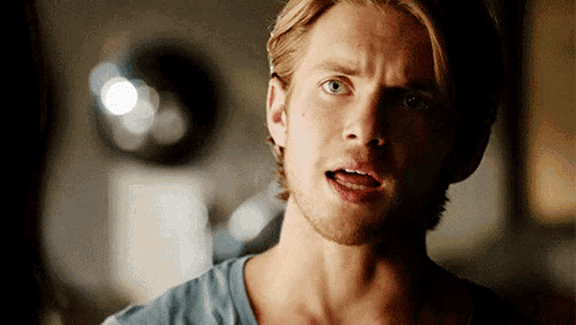 a man with blonde hair and a beard is looking at the camera