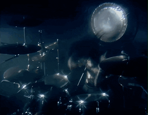 a blurred image of a person playing drums