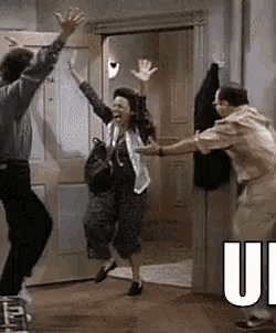 a man and a woman are jumping in the air in front of a door in a room .