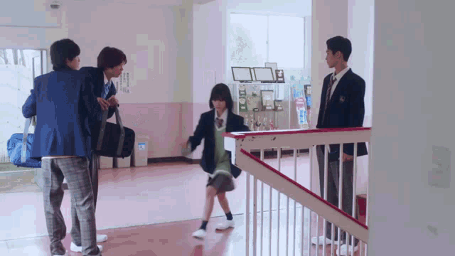 a group of students are standing in a hallway and one of them is holding a bag