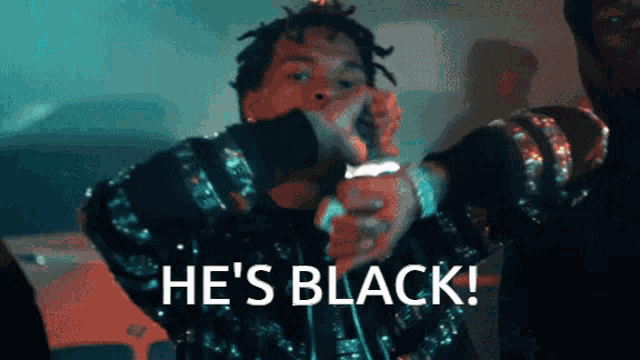 a man singing into a microphone with the words he 's black written below him