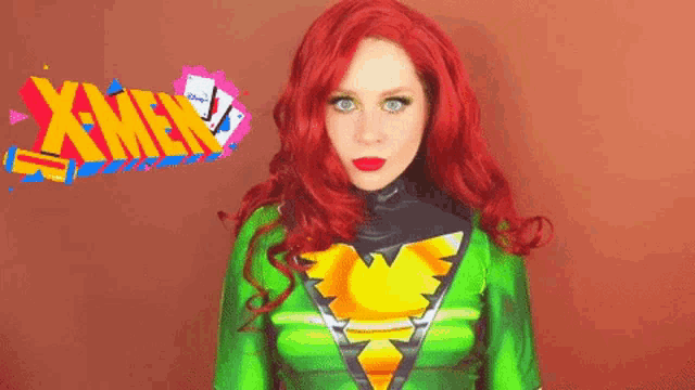 a woman with red hair is wearing a green and yellow costume with the x-men logo behind her