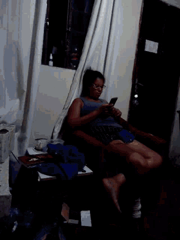 a woman is laying on a couch using a cell phone