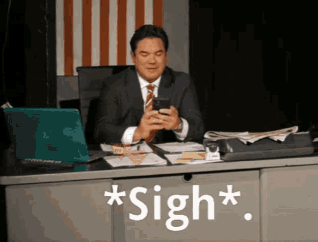 a man in a suit and tie is sitting at a desk looking at his phone with the words * sigh * written below him