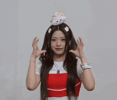 a woman in a red top is holding a stuffed animal