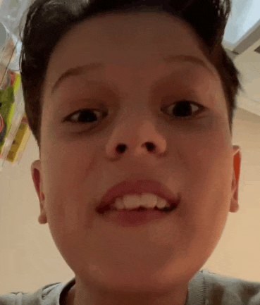 a close up of a young boy 's face with a funny face